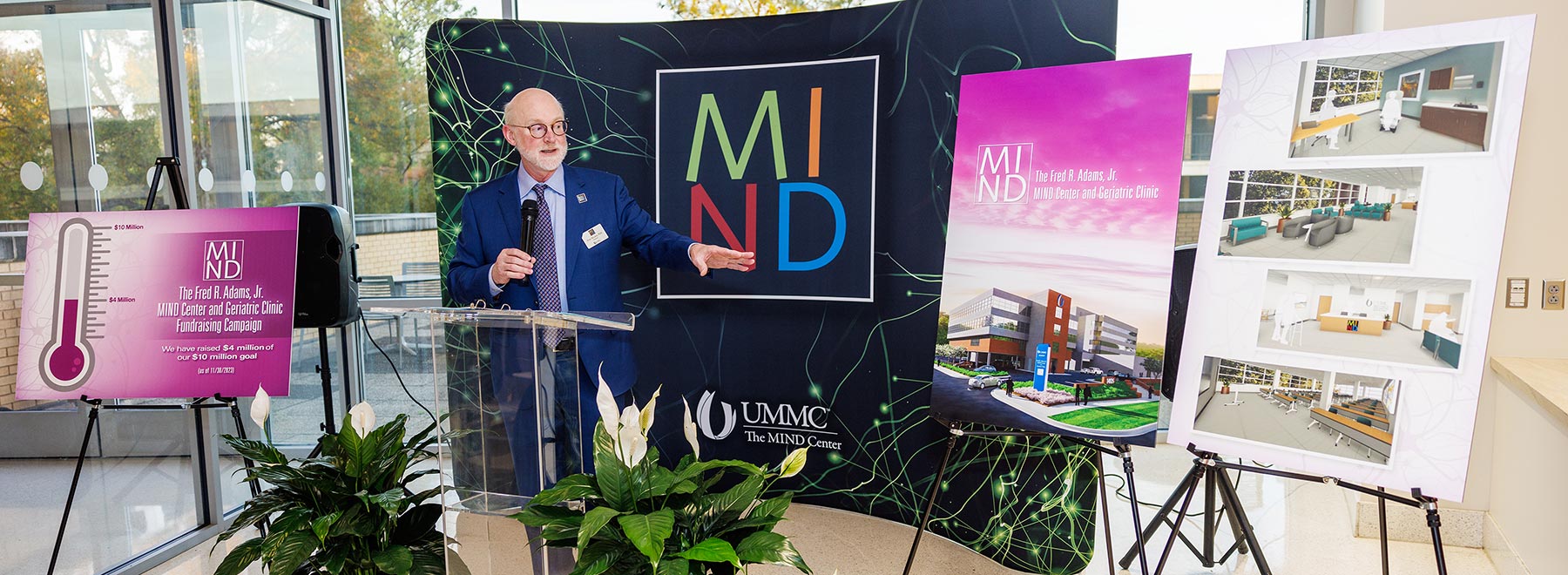 A man speaks at a podium during a MIND Center donor event.